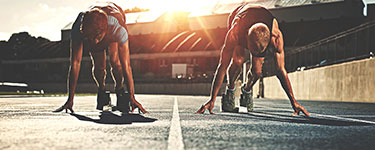 Two men on the strating blocks in a stadium