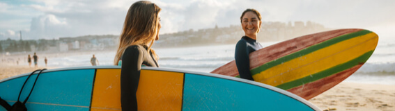 Photo of two surfers shaving a conversation on the beach