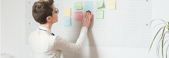 Professional woman placing sticky notes on a board