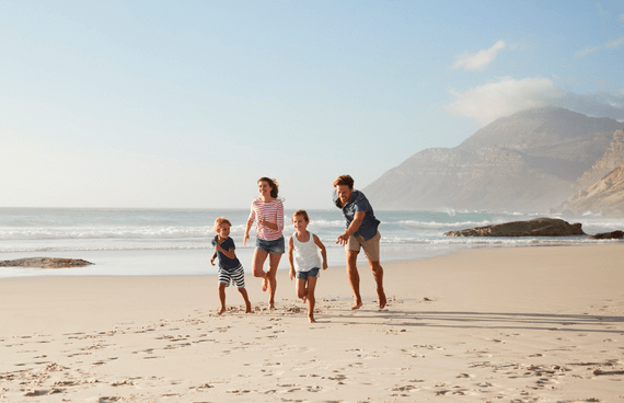 Parents with their children running on a beautiful beach