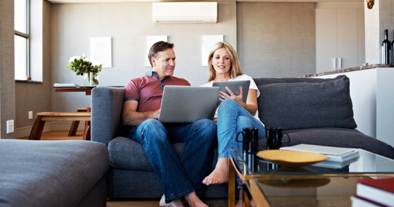 Woman shows her tablet to her spouse on a couch