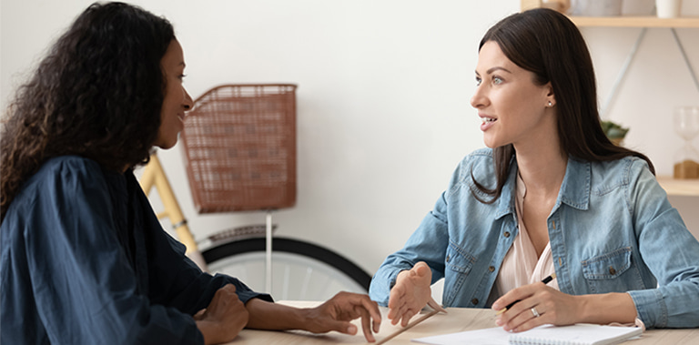 Two people working at a table together.