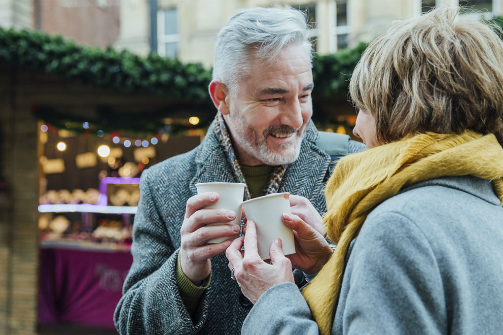Retired couple looking at each other, drinking coffee