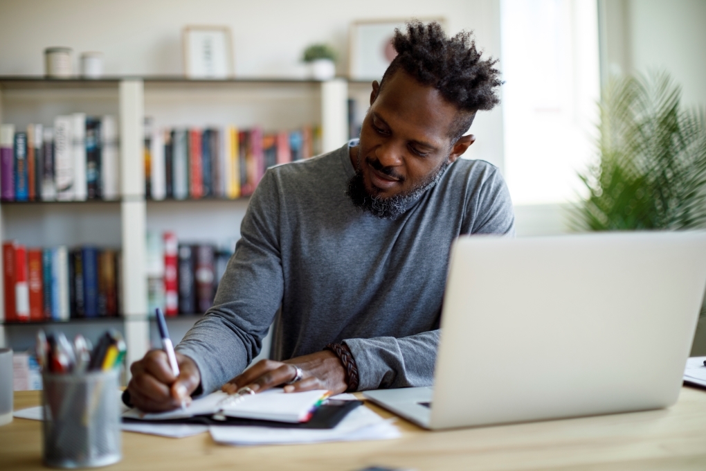 Image for the article on how to make a budget of a man at his desk doing his budget Image for the article on how to make a budget of a man at his desk doing his budget