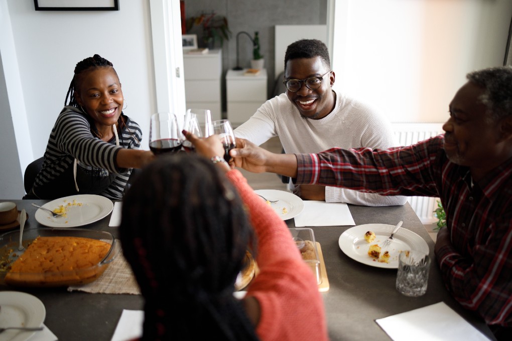 A family makes a toast during a meal. A family makes a toast during a meal.