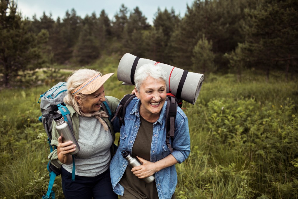 Two retired women hiking with backpacks 