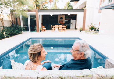 Photo of a retired couple talking by a pool in Florida 
