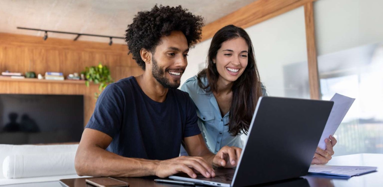 Photo of two people looking at a laptop